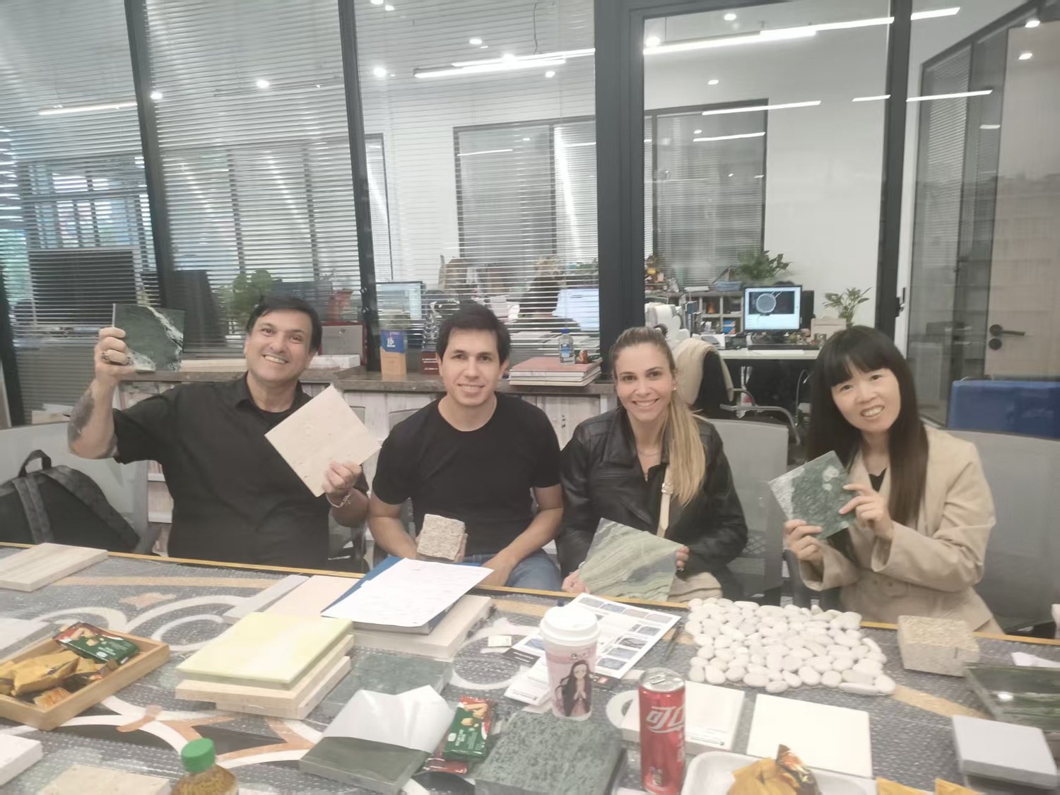 Team discussion around a table with stone samples and project files