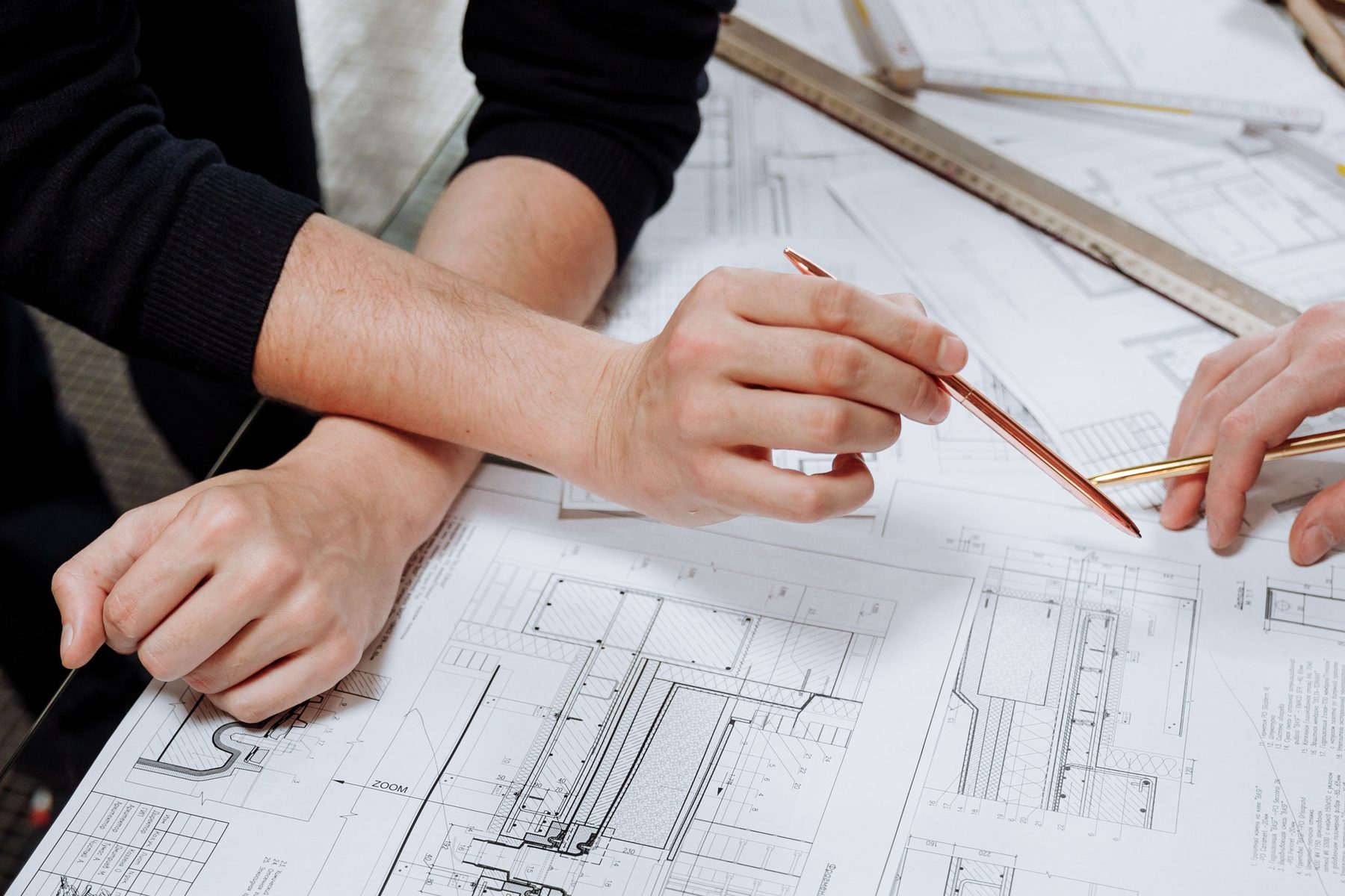 Two people reviewing construction detail drawings together at a table