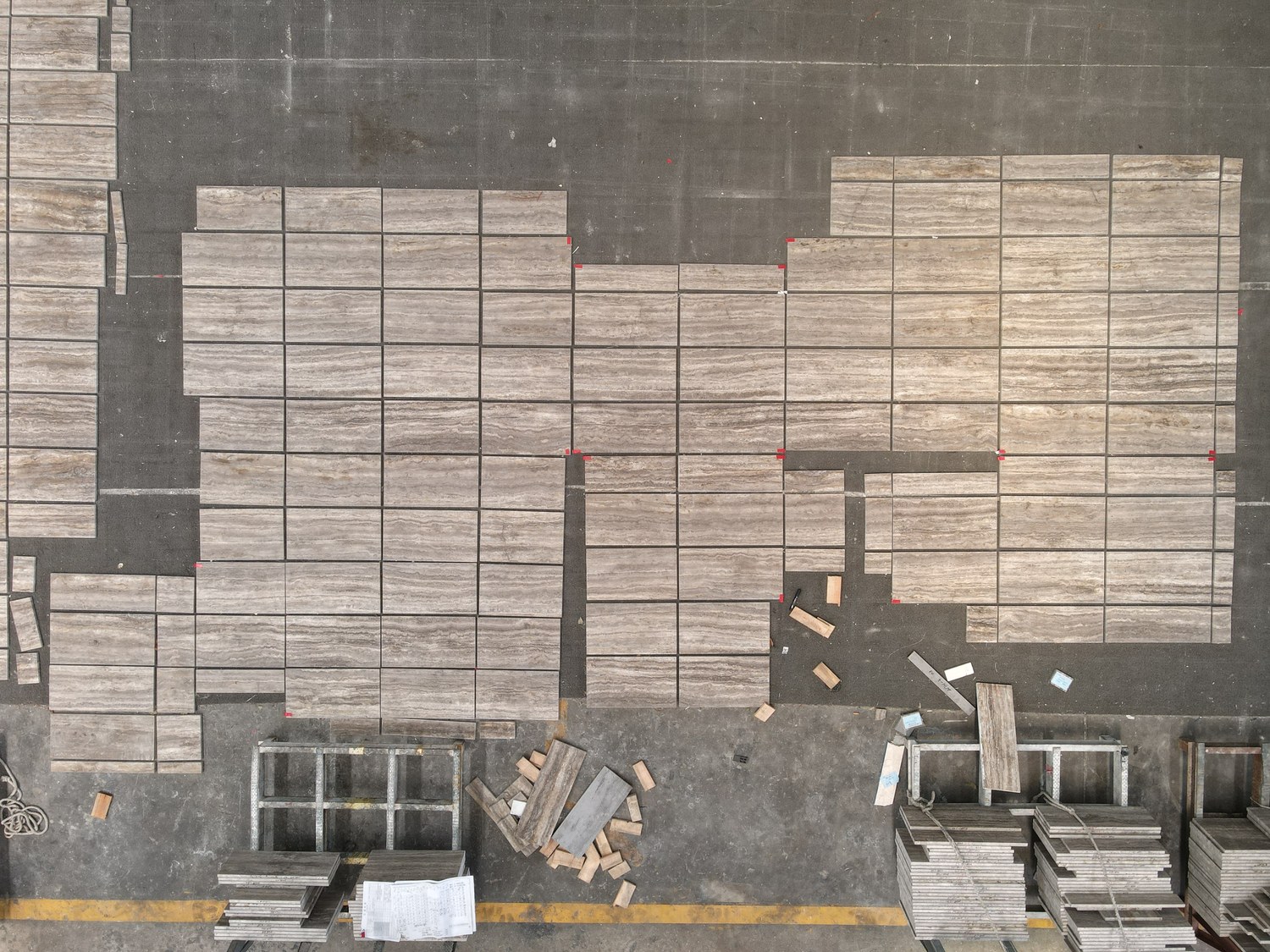 An aerial view of Silver Travertine, vein-cut in a fine linear pattern, laid out in sections with red marker tabs