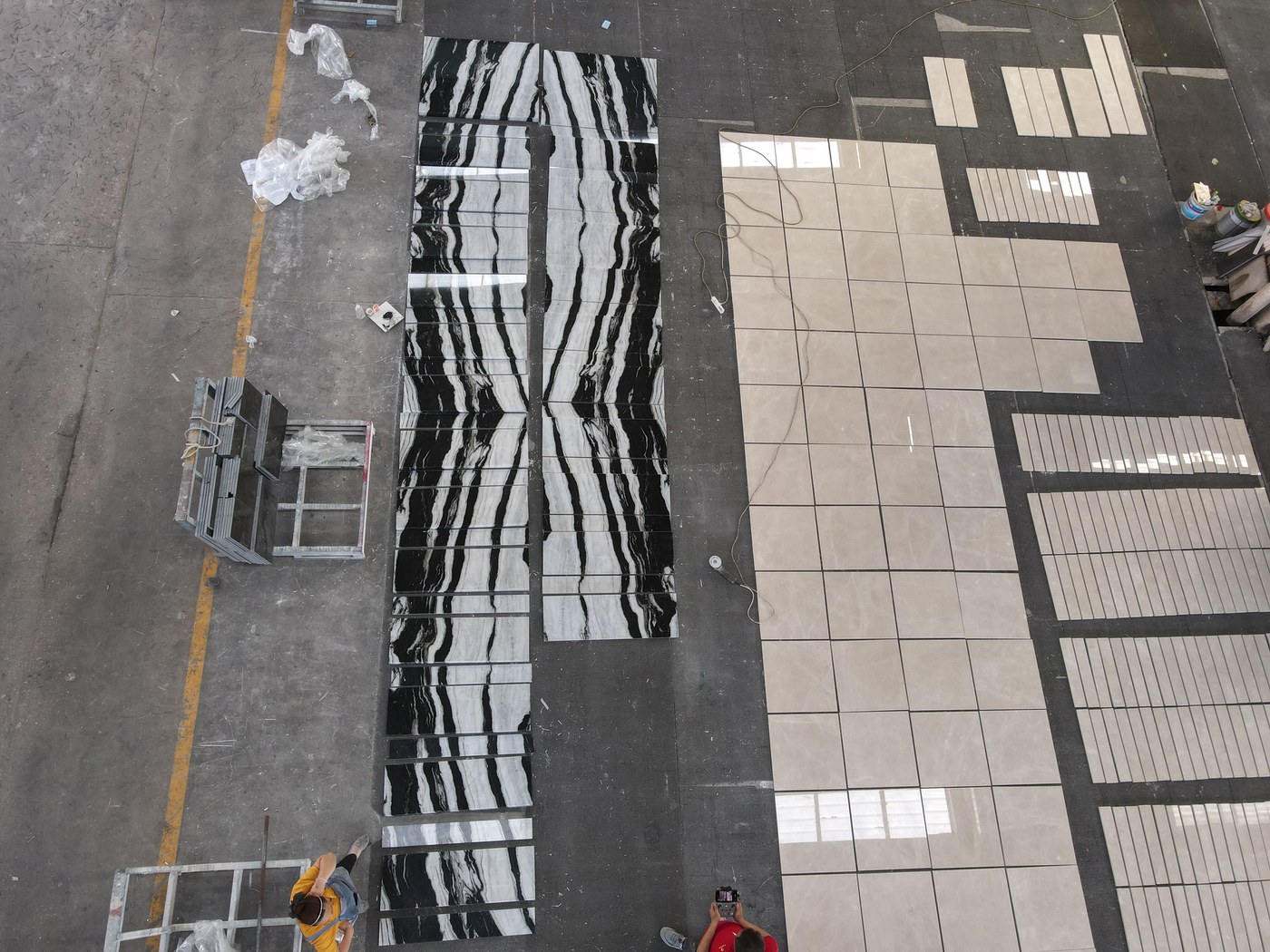 Book-matched Panda White marble laid out in full across the factory floor next to a separate beige stone run