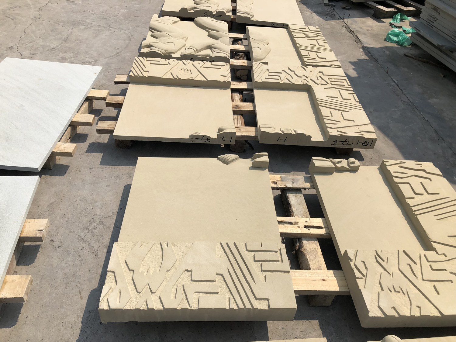 Carved relief panels in sandstone with geometric patterns cut to a consistent depth