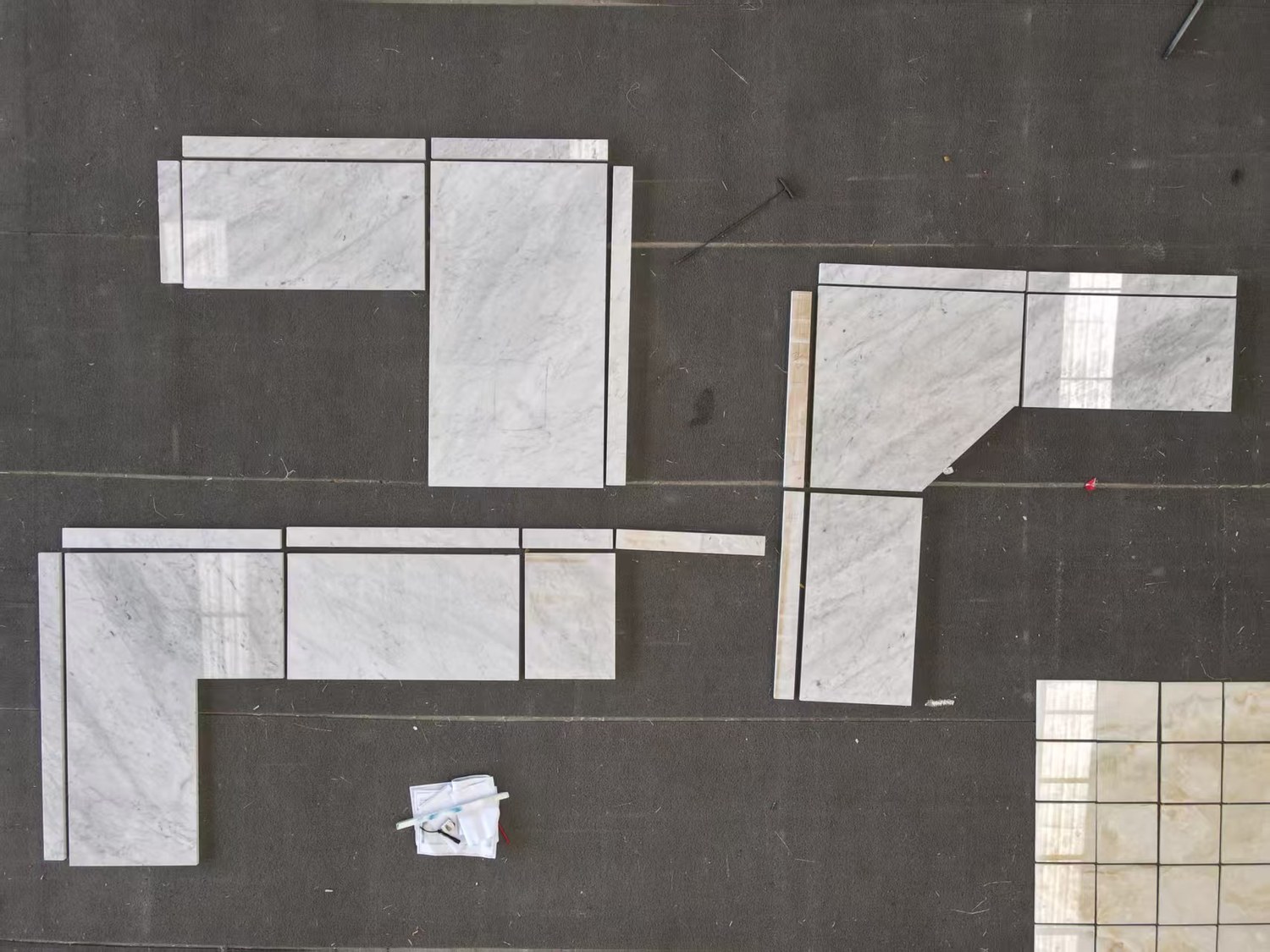 Cut marble pieces numbered and laid out on the factory floor awaiting approval