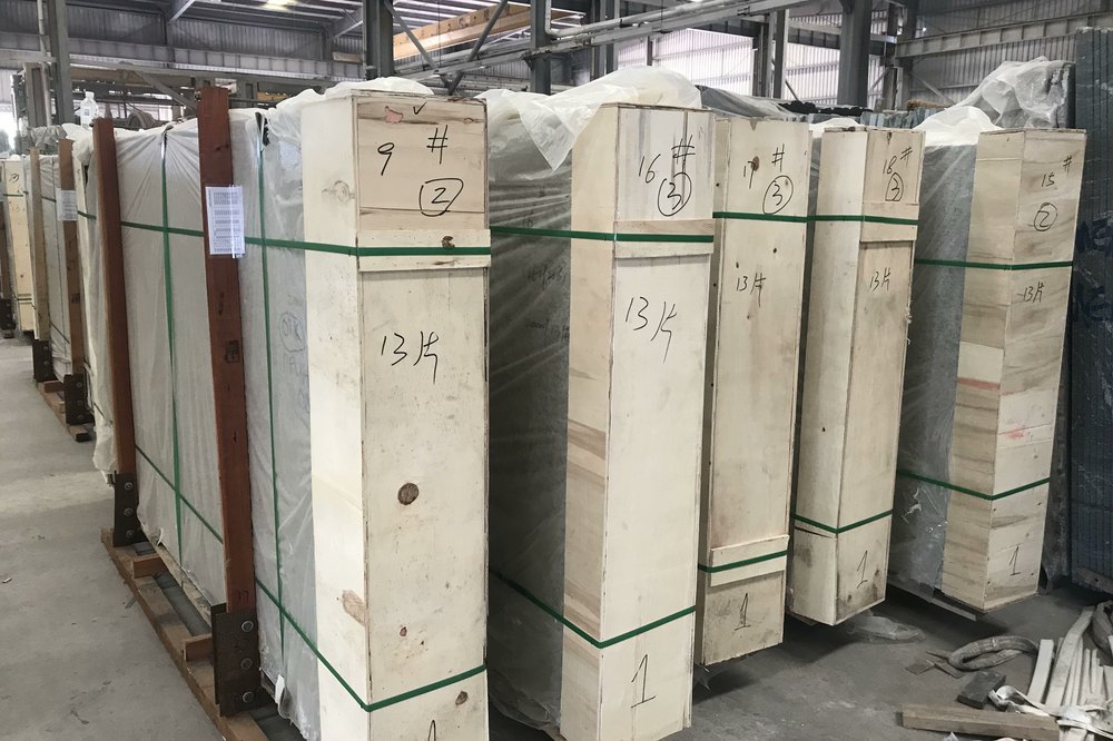 Timber crates of slabs, strapped, sealed and marked with crate numbers and piece counts