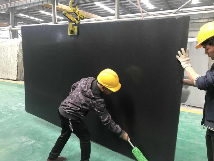 Absolute Black granite slab being cleaned and checked before release