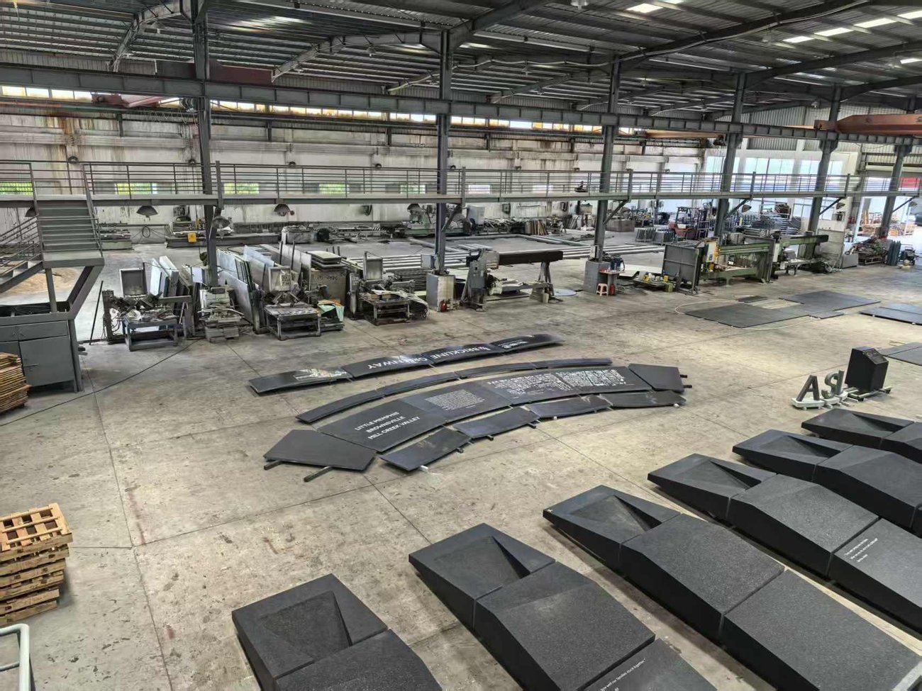 Angola Black granite benches, engraved panels and shaped elements staged on the factory floor